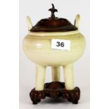 A 19th century Chinese cream glazed terracotta three footed censor with carved hardwood stand and