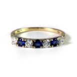 A 9ct yellow gold stone set half eternity ring (R).