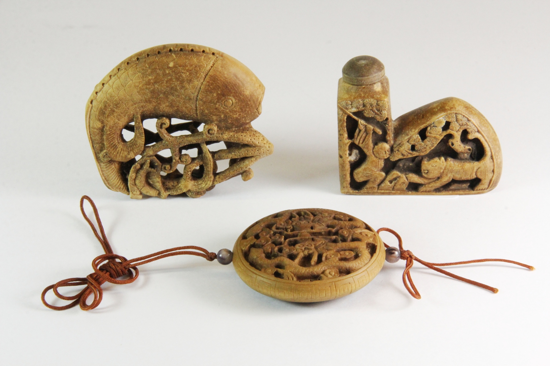 Two mid 20th century Chinese carved wooden snuff bottles and a carved wooden amulet. Prov. The