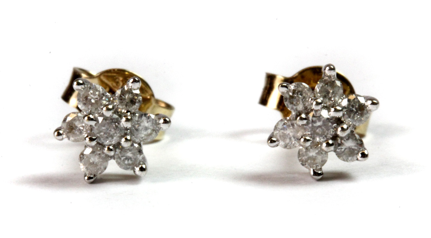 A pair of 9ct yellow and white gold (stamped 375) diamond set flower shaped earrings.