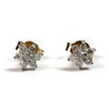 A pair of 9ct yellow and white gold (stamped 375) diamond set flower shaped earrings.