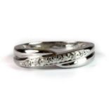 A 9ct white gold diamond set crossover ring (P.5).