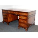 A red leather topped mahogany veneered desk, W. 153 x 92cm