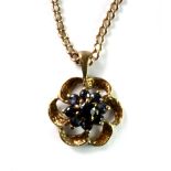 A 9ct yellow gold sapphire set flower shaped pendant and chain.