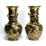 A pair of early 20th century Chinese polished brass vases decorated with dragons in relief, H.