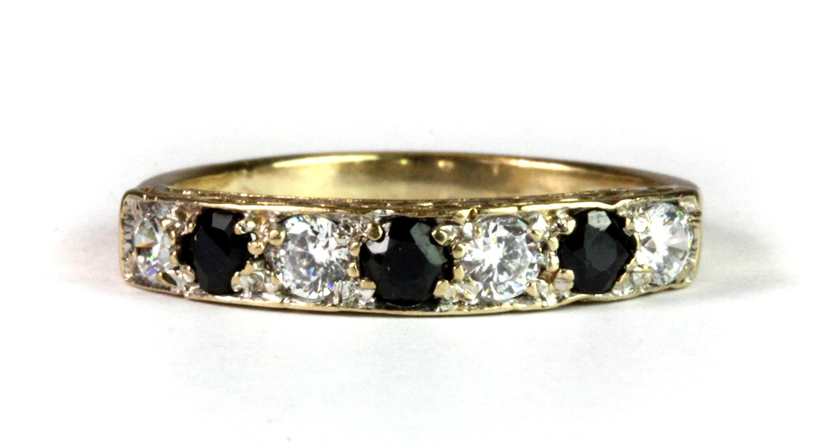 A 9ct yellow gold sapphire and white stone set half eternity ring (P).