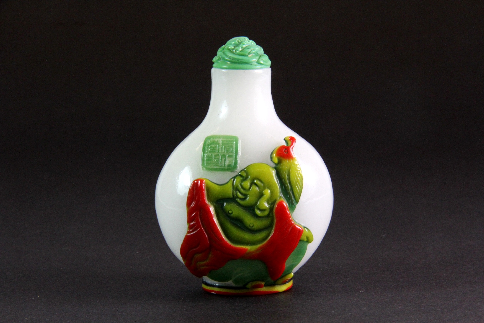 A Chinese four layer Peking glass snuff bottle of the Happy Buddha sitting in a lotus with a faux