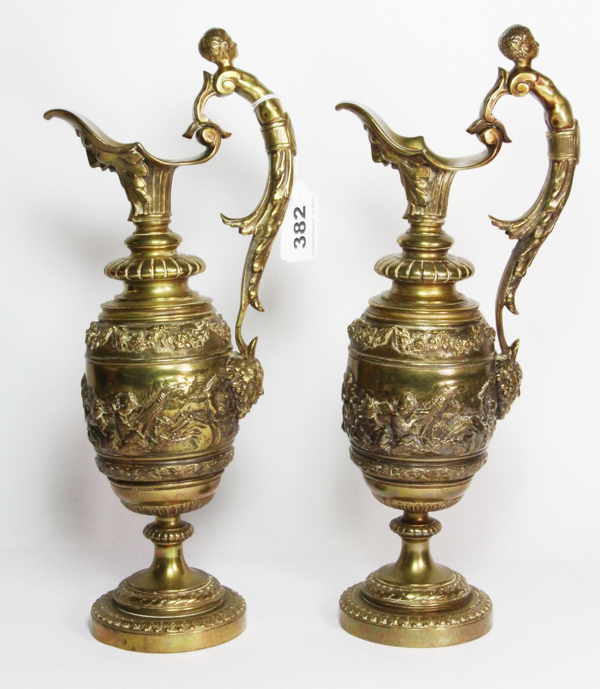 A pair of 19th century French gilt brass ewers, the scroll handle in the form of a semi nude male,
