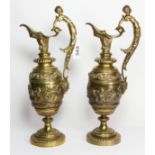 A pair of 19th century French gilt brass ewers, the scroll handle in the form of a semi nude male,