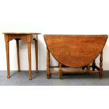 An oak drop leaf dining table and an oak circular pub table.