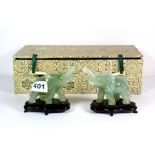 A pair of late 20th century Chinese carved jade figures of elephants on wooden stands, H. 9cm.