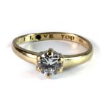 A 9ct yellow gold stone set solitaire ring with an inside inscription "I LOVE YOU" (S).