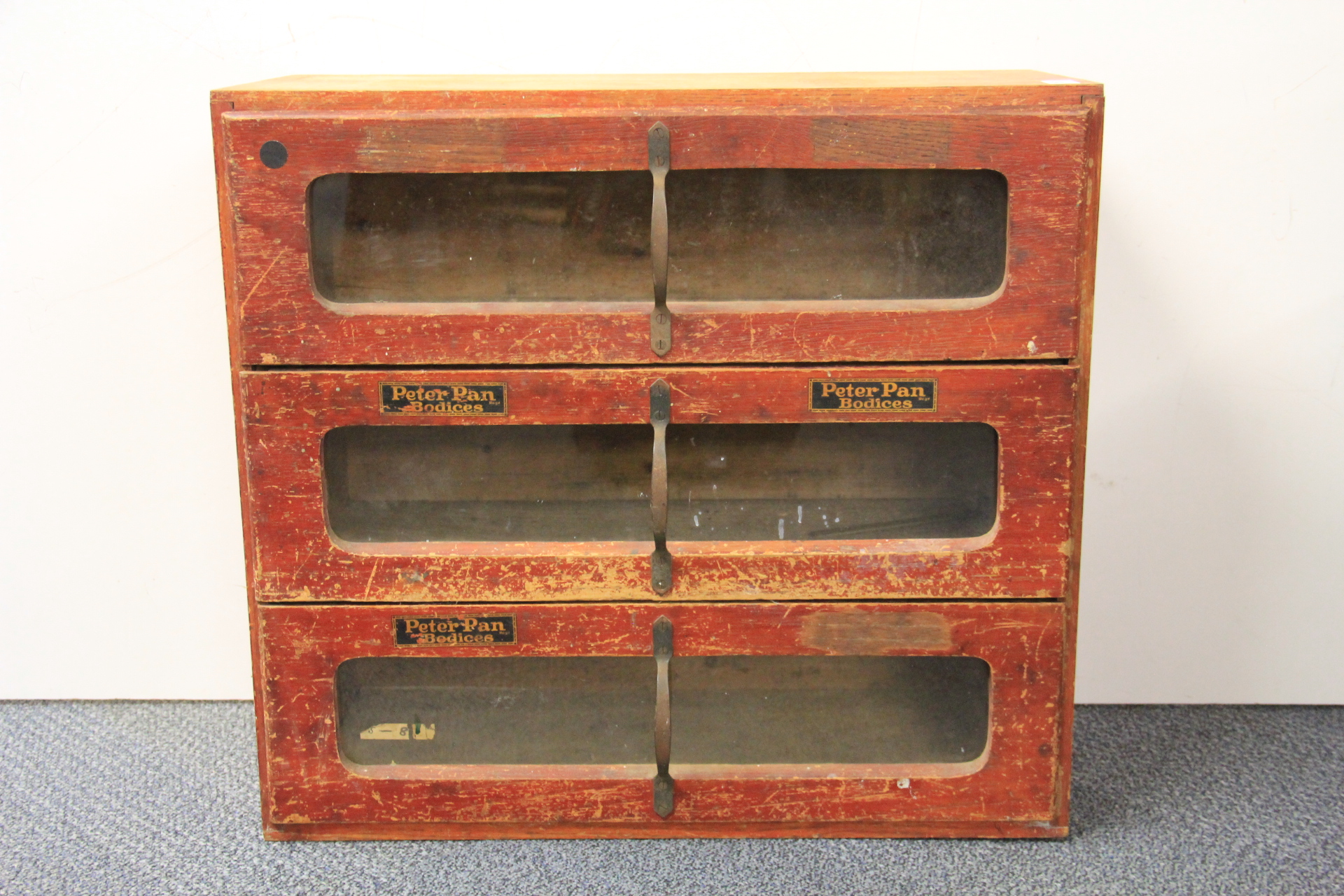 A 1920's pine Peter Pan Bodices advertising and shop display cabinet, 60 x 27 x 56cm.