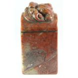 A Chinese carved red and green hardstone scholars seal mounted with a dragon over an arch, H. 9.