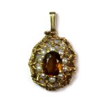 A 9ct yellow gold pendant set with an oval cut citrine and seed pearls.