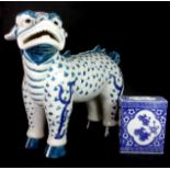 A large mid 20th century oriental pottery lion dog (H. 37cm) and Chinese porcelain stand.