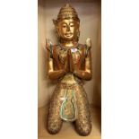 A large Thai gilt and mirror decorated carved wooden figure of a kneeling Buddhist angel, H. 61cm.