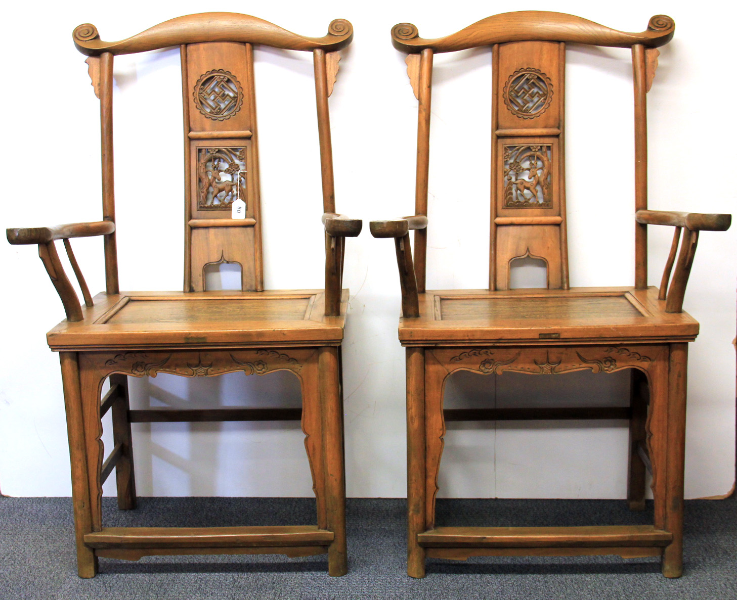 A pair of mid 20th century Chinese carved elm wood arm chairs.