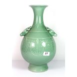 A Chinese incised and celadon glazed porcelain vase with deer head handles and six character mark to