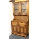 An oak cabinet with leaded glazed doors, W. 93cm, H. 184cm.