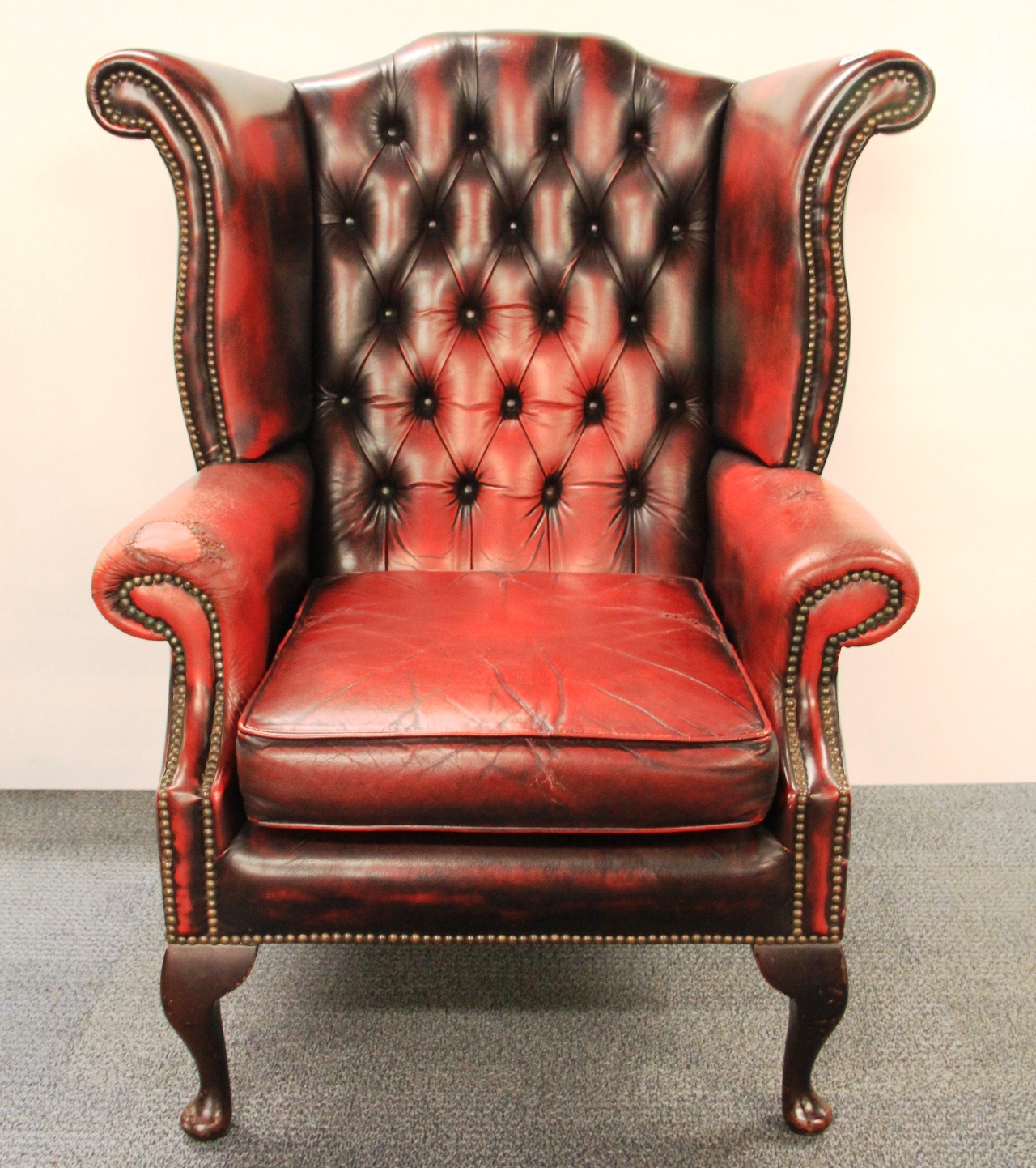 An ox blood leather upholstered wing armchair.