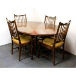 A vintage Stag extending circular / oval drawer leaf dining table and four chairs, bearing
