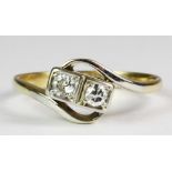 An 18ct yellow gold (stamped 18ct) crossover ring set with two brilliant cut diamonds (K.5).