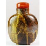 A Chinese carved tigers eye stone snuff bottle with banded agate stopper, H. 7cm.