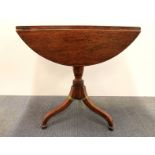 A 19th century circular oak drop leaf tea table with turned pedestal to three spade feet, Dia.