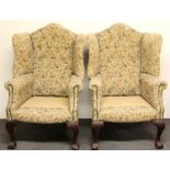 A pair of 1920's ball and claw foot button backed wing chairs.