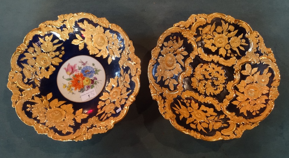 A pair of near matching early 20th century Meissen gilt decorated bowls, on a cobalt blue ground,