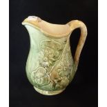 A Majolica-type ale jug (22cm tall), having floral relief decoration.