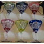 A late 19th/early 20th century cased set of six coloured glass funnel shaped wine glasses,