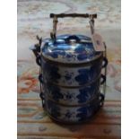 A Chinese ceramic three tier food box, having underglaze blue floral decoration,