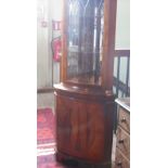 A yew wood veneered floor standing corner cupboard.