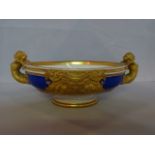 A KPM Berlin porcelain footed dish of oval form, with gilded caryatid handles on a Royal blue,
