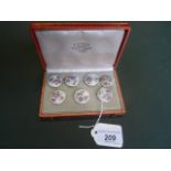 A cased set of seven gilt metal mounted porcelain buttons, the case named E Morgan, Nice, Paris.