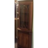 A reproduction yew wood veneered floor standing corner cupboard.