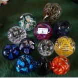 A collection of twelve glass paperweights, to include Murano and Whitefriars examples.