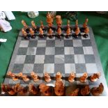 A 19th century Indian carved puzzle ball chess set, on a later granite board,