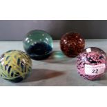 Three glass paperweights, to include one Mdina example.