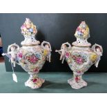 A pair of German hand painted porcelain flower encrusted pot pourri jars and covers,