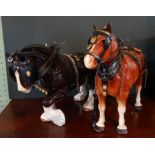 A Melwood ceramic model of a shire horse with tack, together with another, similar (tallest 29cm).