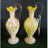 A pair of early 19th century yellow glass ewers, each having loop handle over wavy edged rim,