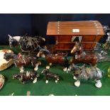 A collection of ceramic horse figurines, to include: a shire pulling a wooden caravan and others.