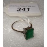 A single stone emerald ring, the rectangular set cut stone in simple claw mounts to plain shank.