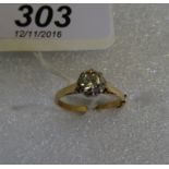 A single stone diamond ring, the brilliant cut diamond in claw mounts within a scalloped band,