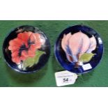 A Moorcroft Hibiscus pattern small pedestal pin dish, on a blue ground,