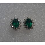 A pair of 18 carat white gold emerald and diamond cluster earrings,