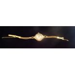 A 9ct gold cased lady's wristwatch, to a corded strap, the enamel dial bearing Roman numerals.